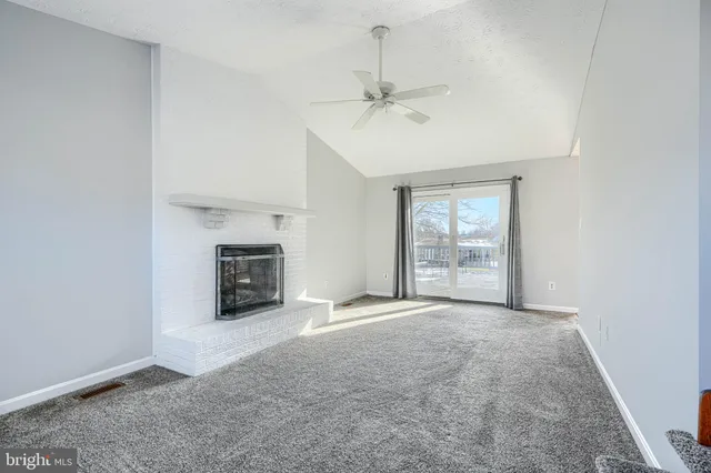 an empty room with windows and fireplace