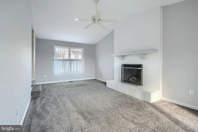 an empty room with windows and fireplace