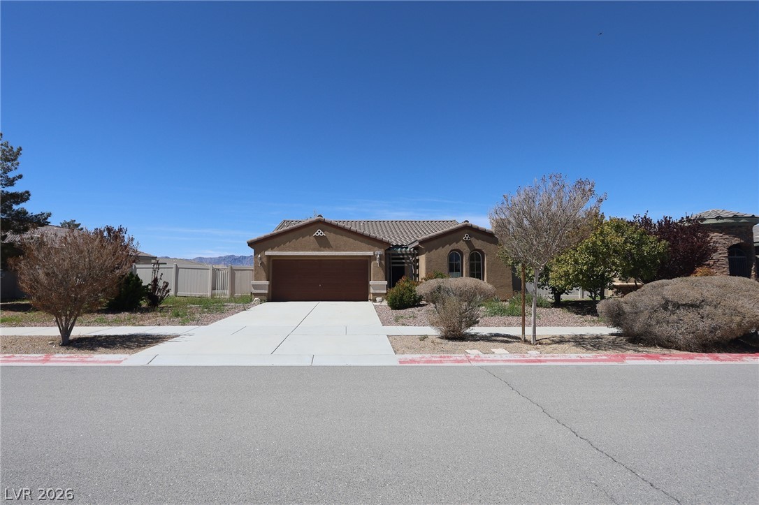 6472 Centennial Road Pahrump, NV 89048 - Photo 2 of 29 A well-maintained single-story home with a two-car garage offers inviting desert curb appeal.