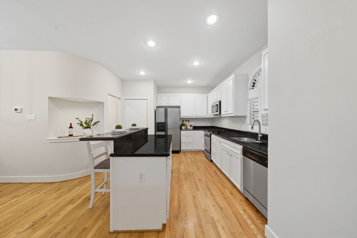 5817 Darling Street, Unit D Houston, TX 77007 - Photo 23 of 40 a large white kitchen with stainless steel appliances granite countertop a sink and a stove