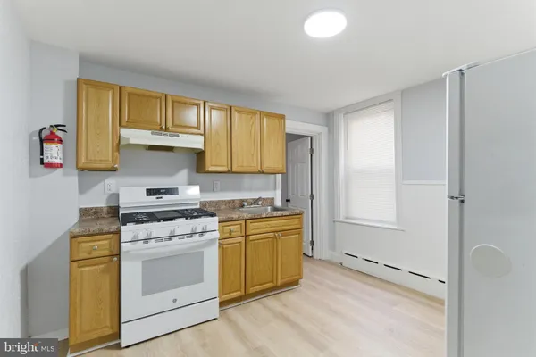 a view of a kitchen with a sink refrigerator and stove