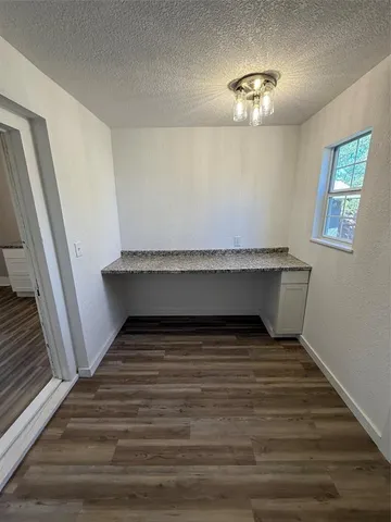 a view of a room with gym equipment and wooden floor