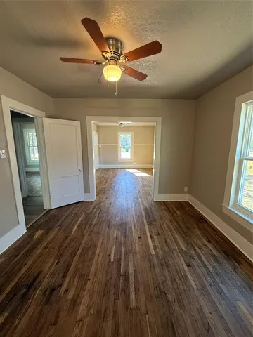 a view of a livingroom with wooden floor and staircase
