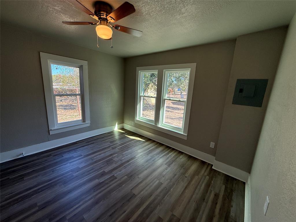 705 East 9th Street Coleman, TX 76834 - Photo 21 of 29 a view of an empty room with window and wooden floor