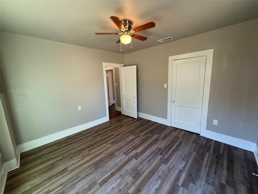 705 East 9th Street Coleman, TX 76834 - Photo 23 of 29 an empty room with wooden floor and ceiling fan