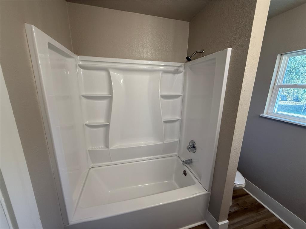 705 East 9th Street Coleman, TX 76834 - Photo 25 of 29 a bathroom with a tub and a shower