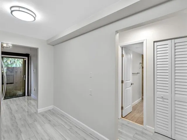 a view of a hallway with wooden floor