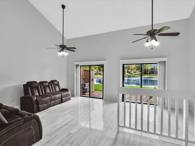 a living room with furniture ceiling fan and a window