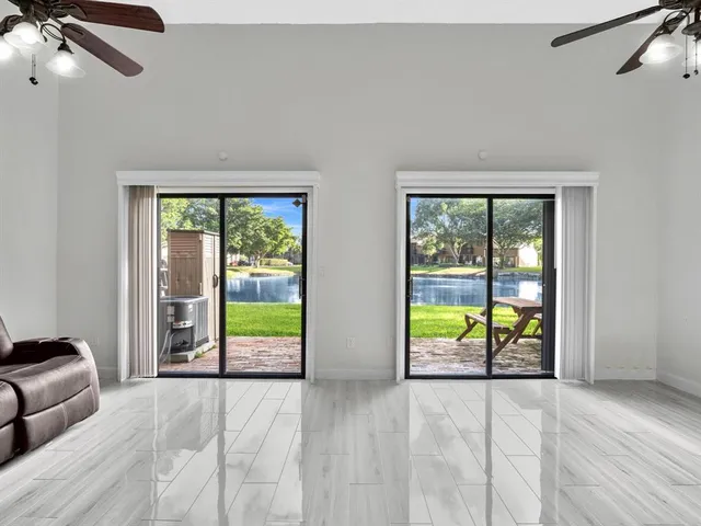 a view of a livingroom with a furniture ceiling fan and window
