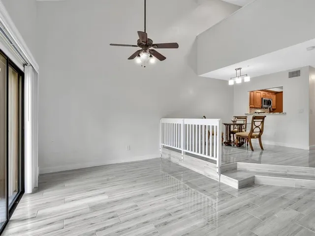 a living room with furniture a ceiling fan and a rug