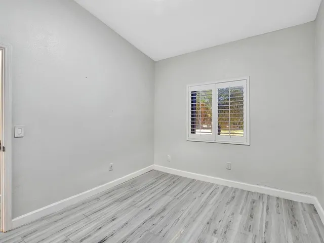 a spacious bedroom with a bed a chandelier and a table