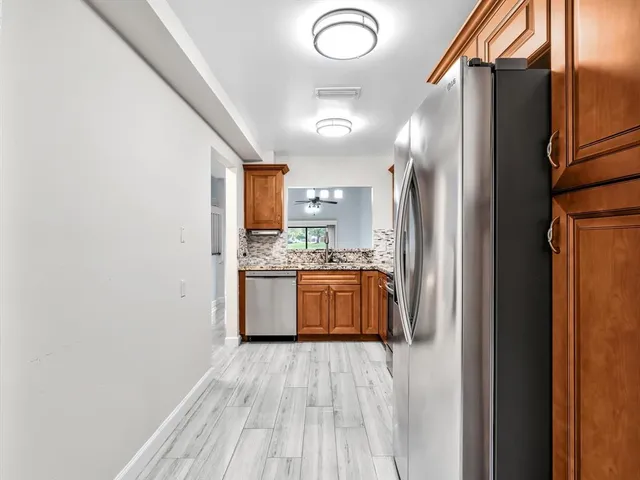 a kitchen with stainless steel appliances granite countertop a refrigerator and a sink