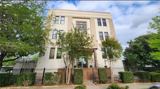 a front view of a house with a tree