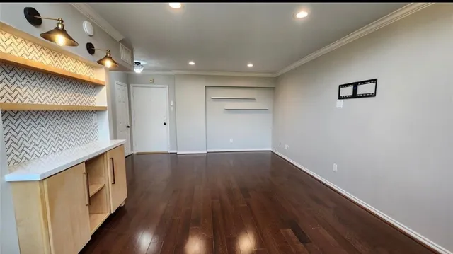 a view of an empty room with wooden floor