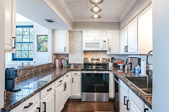 a kitchen with stainless steel appliances granite countertop a stove sink and cabinets
