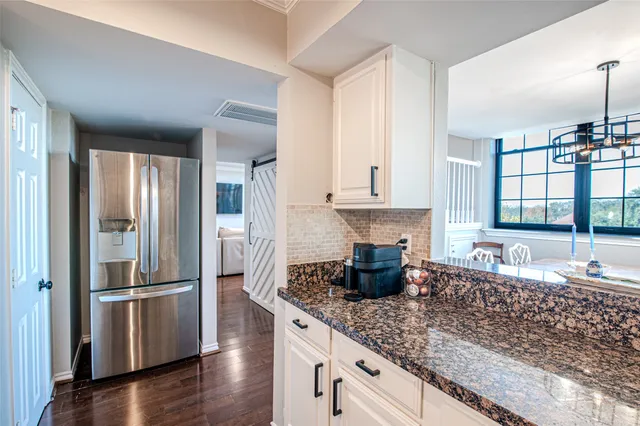 a kitchen with stainless steel appliances granite countertop a refrigerator and a sink
