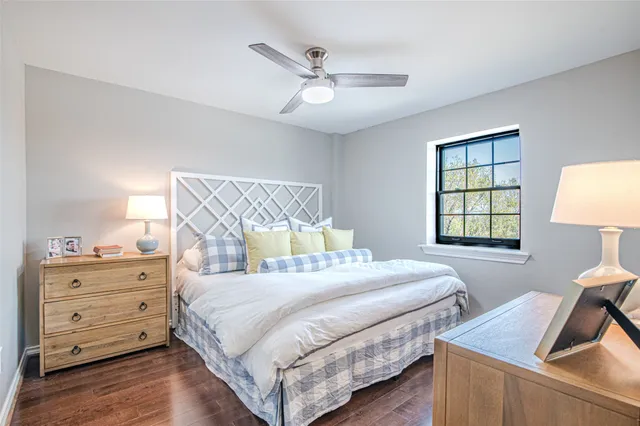 a bedroom with a bed and a dresser next to a window