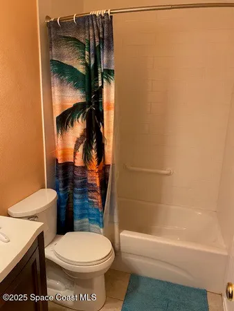 a bathroom with a toilet and a shower curtain