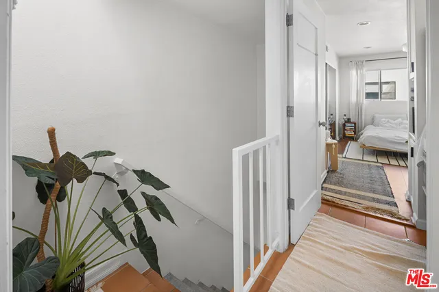 a view of a hallway with wooden floor and stairs
