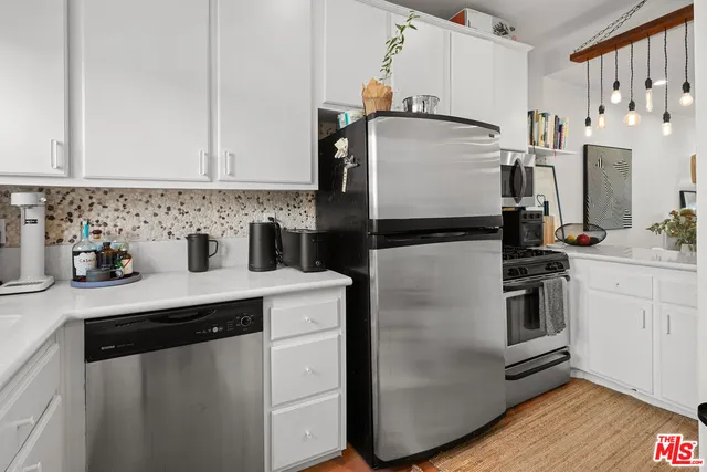 a kitchen with stainless steel appliances and white cabinets