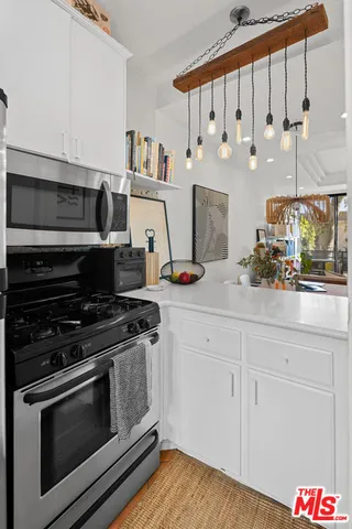 a kitchen with stainless steel appliances granite countertop a stove and a white cabinets