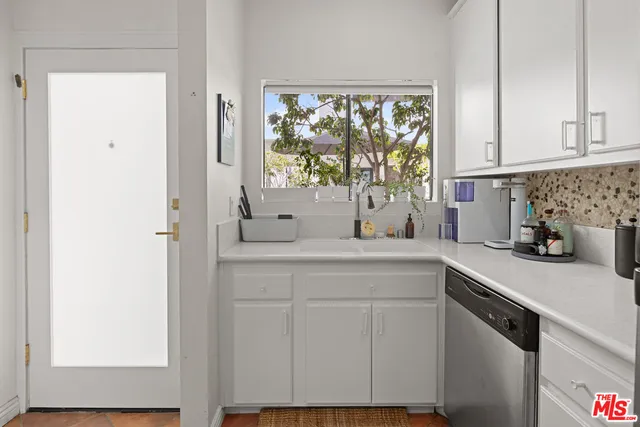 a kitchen with stainless steel appliances white cabinets and a window