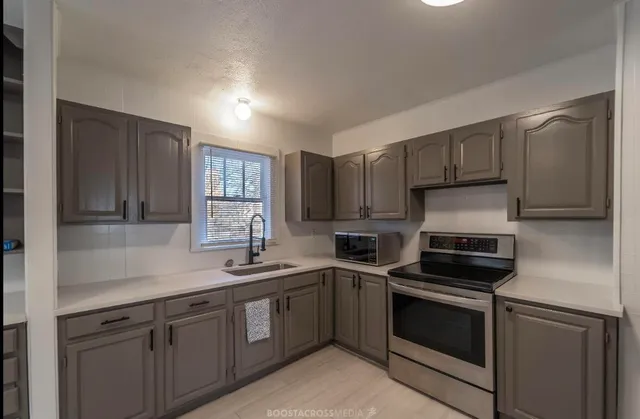 a kitchen with a sink stove and microwave