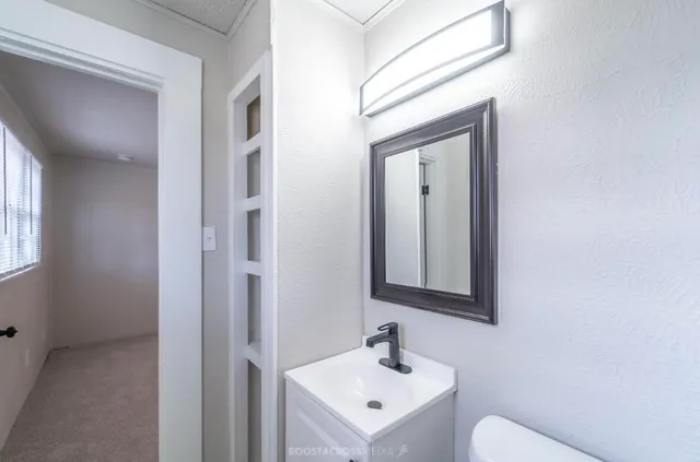 a bathroom with a toilet sink and mirror
