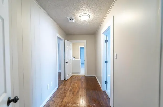 a view of a hallway with wooden floor