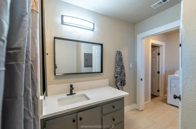 a bathroom with a sink a light fixture and a mirror