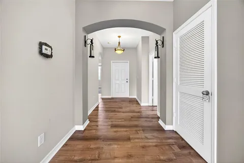 a view of a hallway with wooden floor and staircase