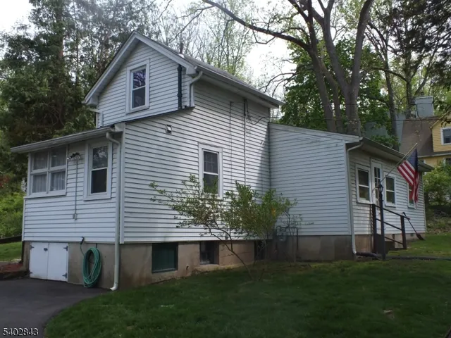 a front view of a house with a garden and trees