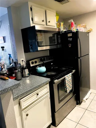 a kitchen with stainless steel appliances granite countertop a refrigerator and a stove top oven