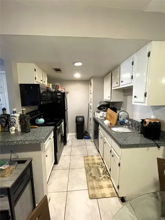 a kitchen with granite countertop a sink stove and cabinets