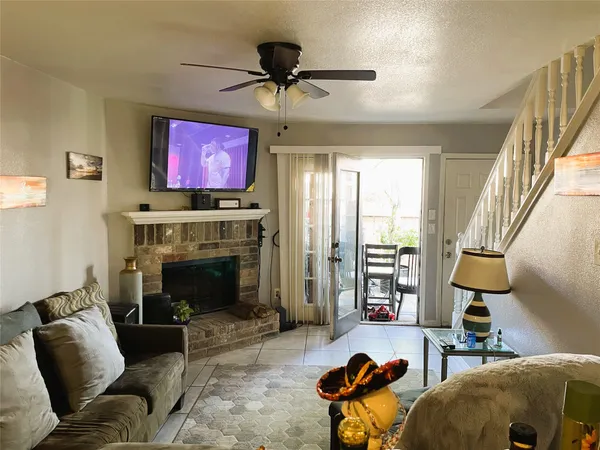 a living room with furniture a fireplace and a flat screen tv