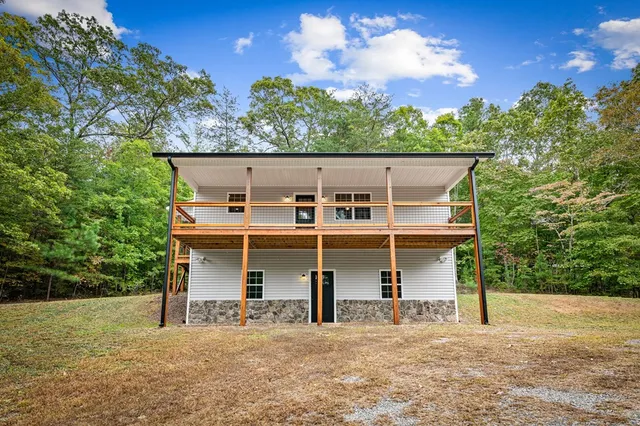 a view of a house with backyard and trees