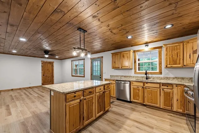 a large kitchen with stainless steel appliances granite countertop a lot of counter space