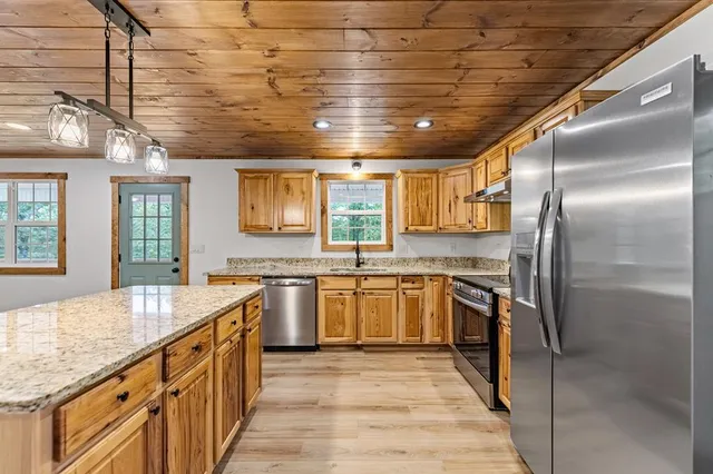 a kitchen with stainless steel appliances granite countertop a sink stove and refrigerator