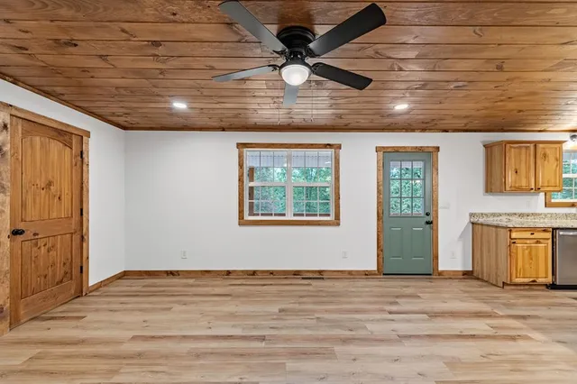 a room with lots of wooden furniture and large windows