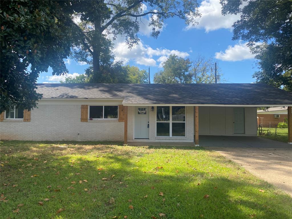 a view of a house with a yard and large tree