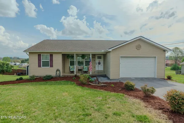 a front view of a house with a yard and outdoor seating