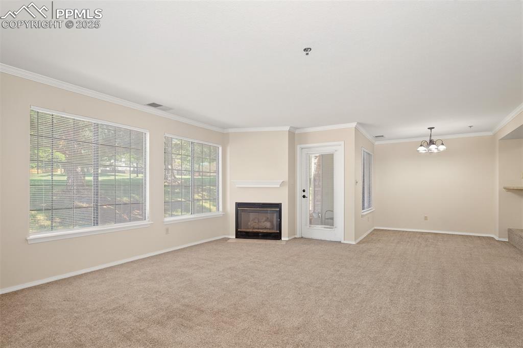2190 Alicia Point, Unit 101 Colorado Springs, CO 80919 - Photo 3 of 33 an empty room with fireplace and windows