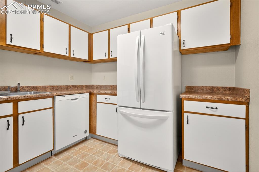 2190 Alicia Point, Unit 101 Colorado Springs, CO 80919 - Photo 10 of 33 a white refrigerator freezer sitting inside of a kitchen