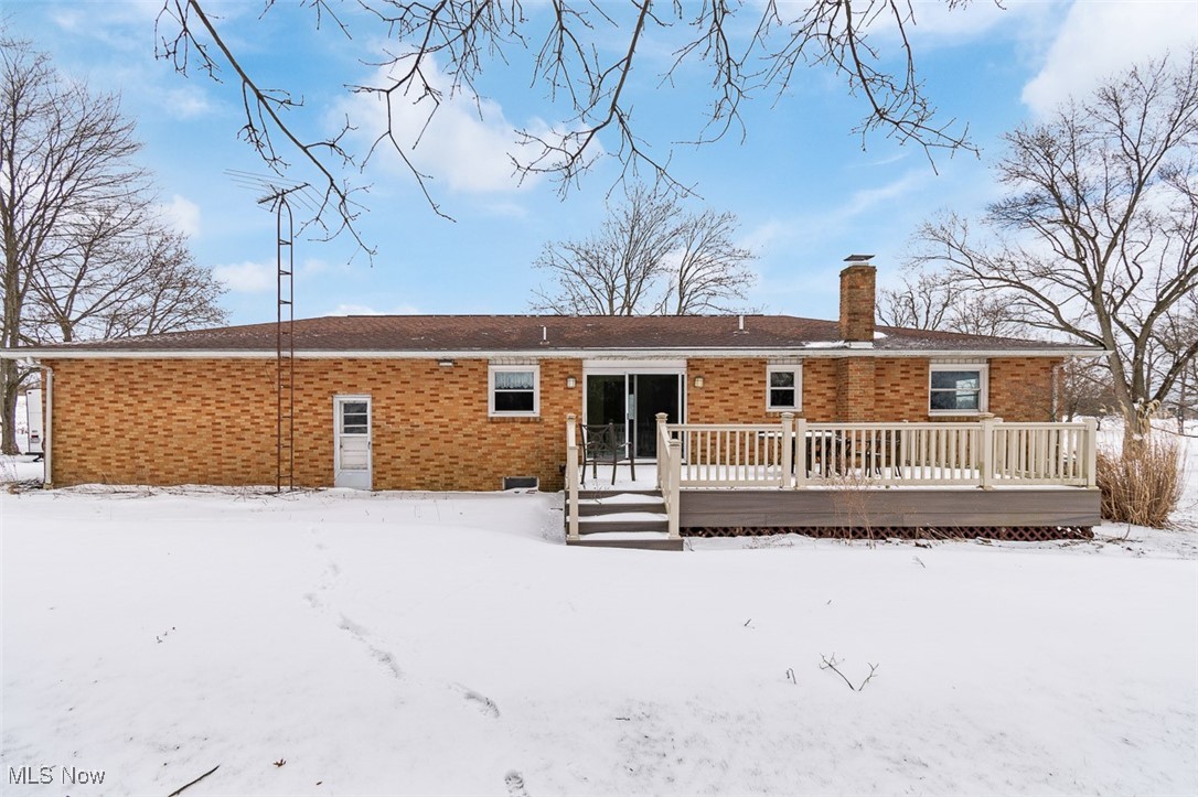 5208 Canaan Center Road Wooster, OH 44691 - Photo 27 of 33 Snow covered rear of property with a wooden deck, brick siding, and a chimney