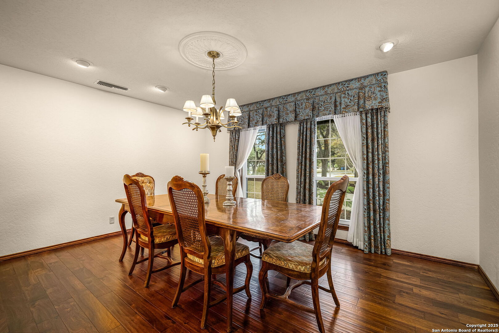9606 Meadow Rue Garden Ridge, TX 78266 - Photo 20 of 60 a view of a dining room with furniture a chandelier and wooden floor