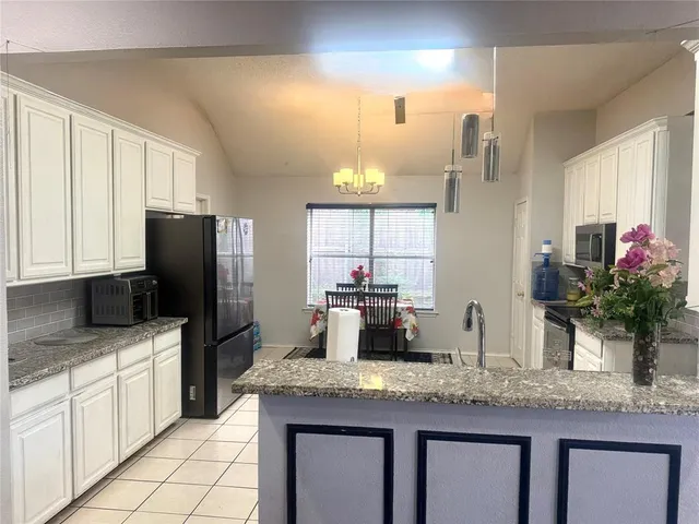 a kitchen with granite countertop a sink stainless steel appliances and cabinets