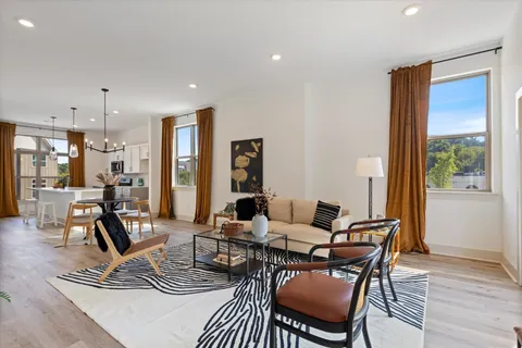 a living room with furniture a rug and white walls