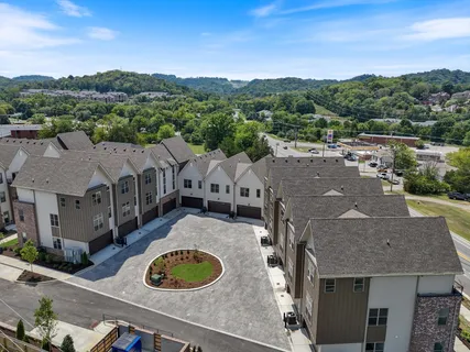 a aerial view of a house in a big yard with large tree
