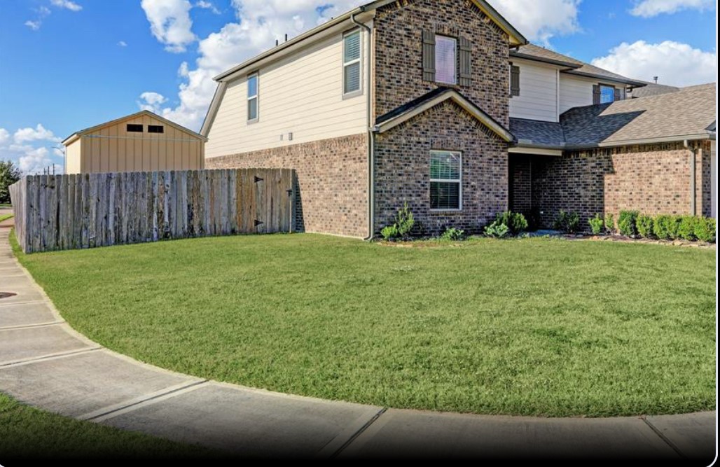 a view of a house with a yard and pathway