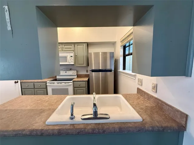 a view of kitchen with kitchen island and windows